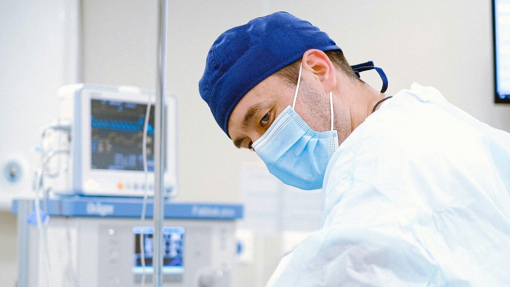 A surgeon performing a procedure in a sterile operating room setting.